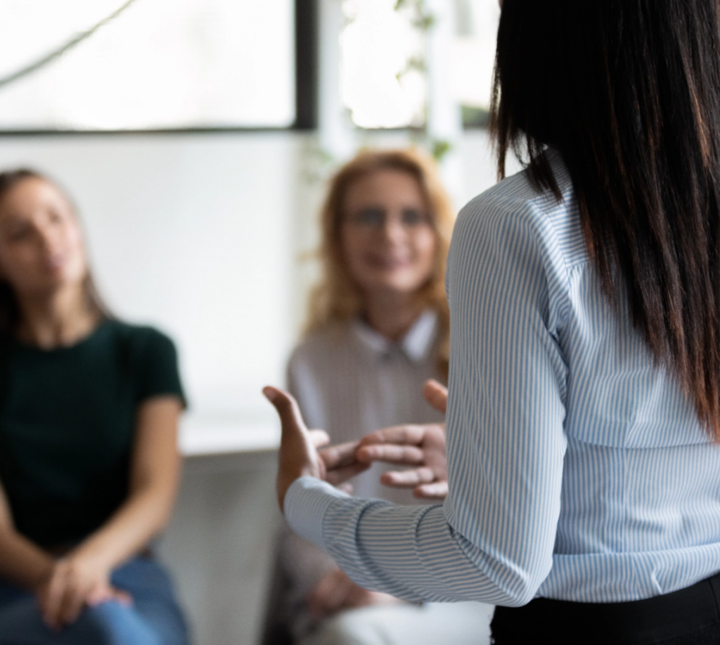 Closer look of a the back of a woman explaining something to others