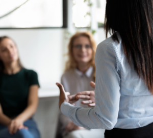 Closer look of a the back of a woman explaining something to others