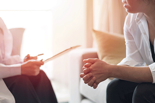 Hands of a client and doctor in a mental health treatment session