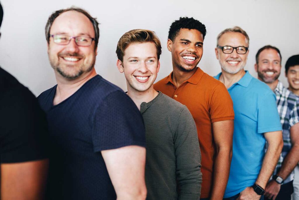 group of men smiling and discussing the stigma of addiction in men's rehab