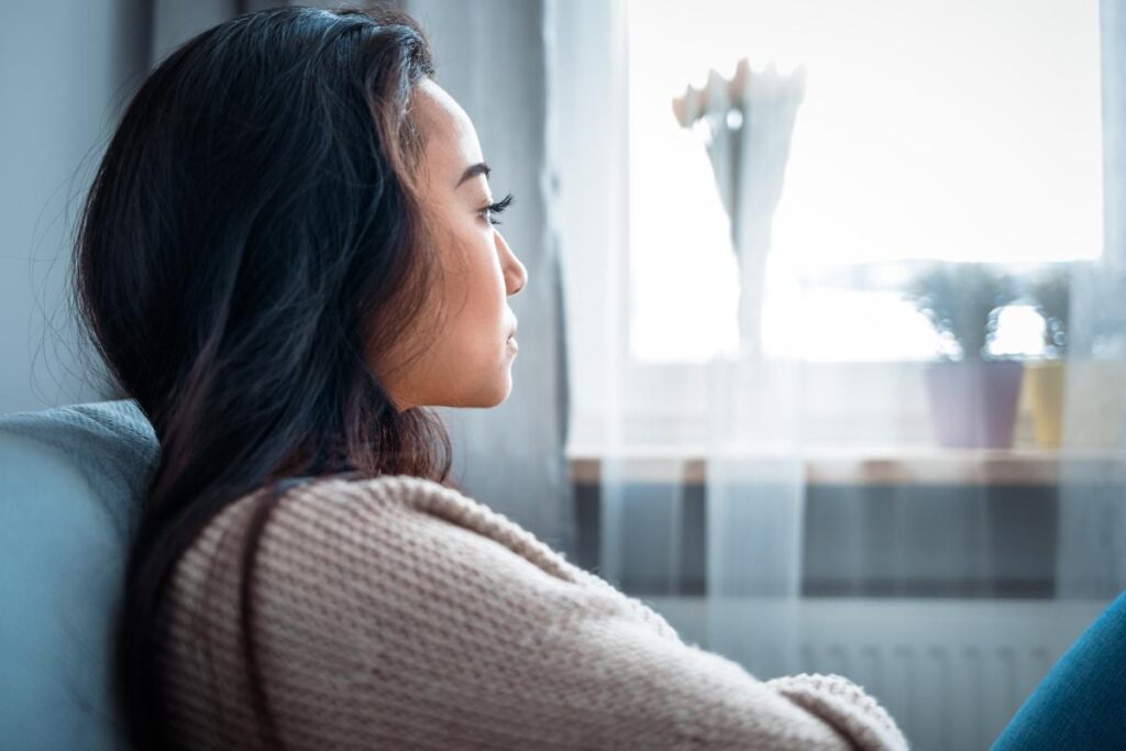 woman looking out of the window and considering the most common co-occurring disorders