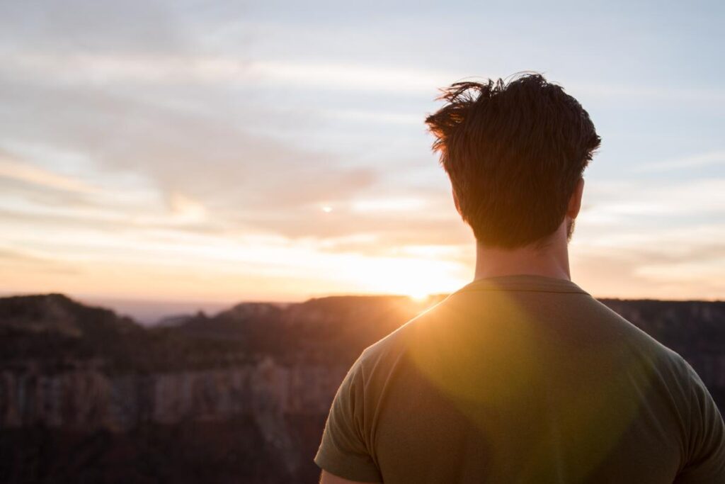 man looks out at sunset and considers how to overcome alcohol addiction